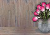 Pink tulip and willow branches on wood texture