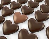 Heart shaped milk chocolate candy between dark ones