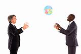 two businessmen playing with a globe