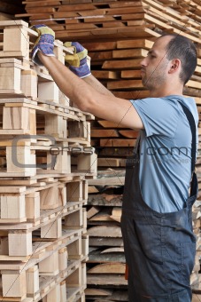 Man arraging pallets, vertical shot