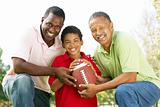 Grandfather With Son And Grandson In Park With American Football