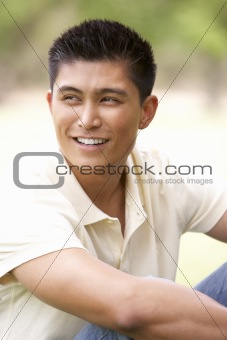 Portrait Of Young Man Sitting In Park