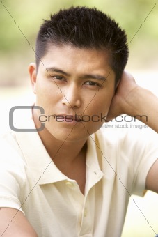 Portrait Of Young Man Sitting In Park
