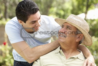 Senior Man With Adult Son In Garden