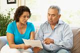 Senior Couple Studying Financial Document At Home