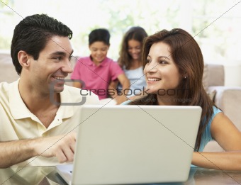 Parents Using Laptop At Home