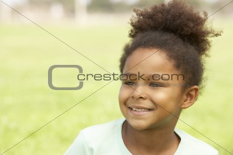 Portrait Of Young Girl Sitting In Park