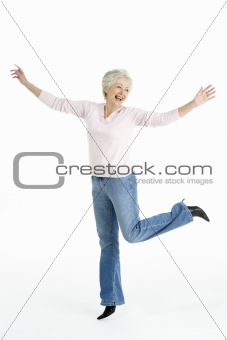 Full Length Studio Portrait Of Smiling Senior Woman