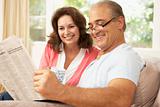 Senior Couple Reading Newspaper At Home