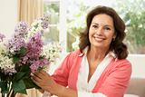 Senior Woman At Home Arranging Flowers