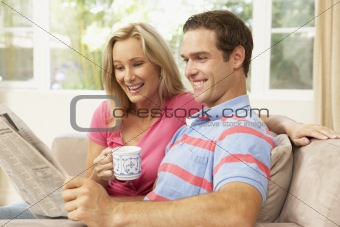 Couple Reading Newspaper At Home