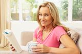 Woman Reading Book With Drink At Home