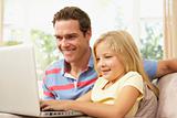 Father And Daughter Using Laptop At Home