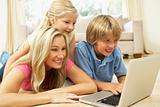 Mother And Children Using Laptop At Home