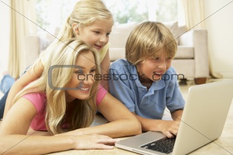 Mother And Children Using Laptop At Home