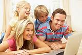 Family Using Laptop At Home Together