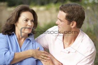 Senior Woman Being Comforted By Adult Son