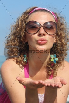 Beautiful curly woman sending a kiss