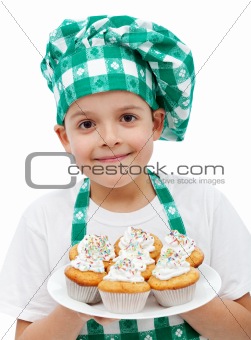 Happy chef boy with a plate of muffins