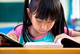 little girl studying in classroom at school