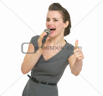 Singing in microphone woman showing thumbs up