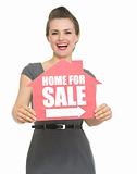 Happy realtor showing home for sale sign