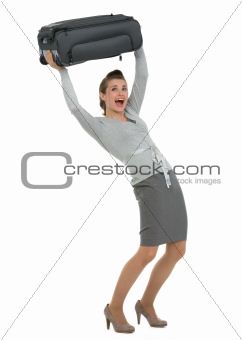 Traveling woman raising suitcase above head