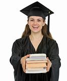 Graduation girl student giving stack of books