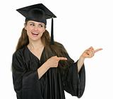 Happy graduation student girl pointing sideways