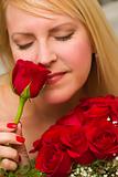 Beautiful Woman Smelling a Bunch of Red Roses.