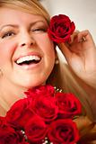 Beautiful Woman with a Bunch of Red Roses and Places One Above Her Ear.