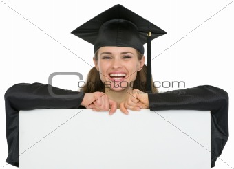 Happy graduation student girl with blank billboard