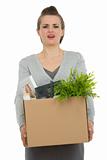 Fired woman employee holding box with personal items