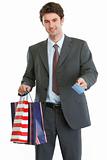 Man in suit holding shopping bags and credit card