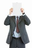 Modern businessman holding blank paper sheet in front of face