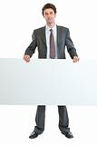 Full length portrait of businessman holding blank billboard