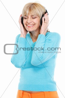 Happy middle age woman listening music in headphones