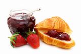 Croissant with strawberry jam and fresh berries.
