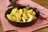 fresh potatoes fried in a pan on a wooden table