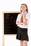 Thoughtful Female Student Wearing Uniform Next To Blackboard