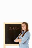 Female Student Standing Next To Blackboard