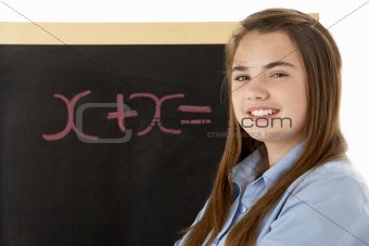 Female Student Standing Next To Blackboard