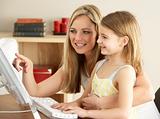 Mother And Daughter At Home Using Computer