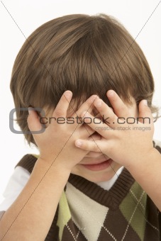 Studio Portrait Of Young Boy Covering Eyes