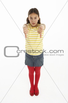 Studio Portrait Of Defiant Young Girl Giving Thumbs Down Gesture