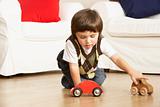 Young Boy Playing With Toy Cars At Home