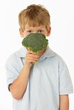 Studio Portrait Of Young Boy Holding Broccoli