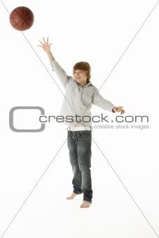 Young Boy Jumping With Basketball In Studio