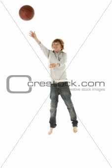 Young Boy Jumping With Basketball In Studio