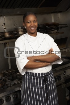 Female Chef Standing Next To Cooker In Restaurant Kitchen